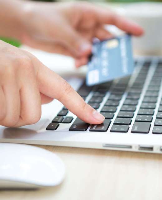 Hands holding a credit card and using laptop computer for online shopping