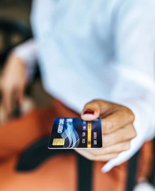 Woman submitting credit card to pay for goods